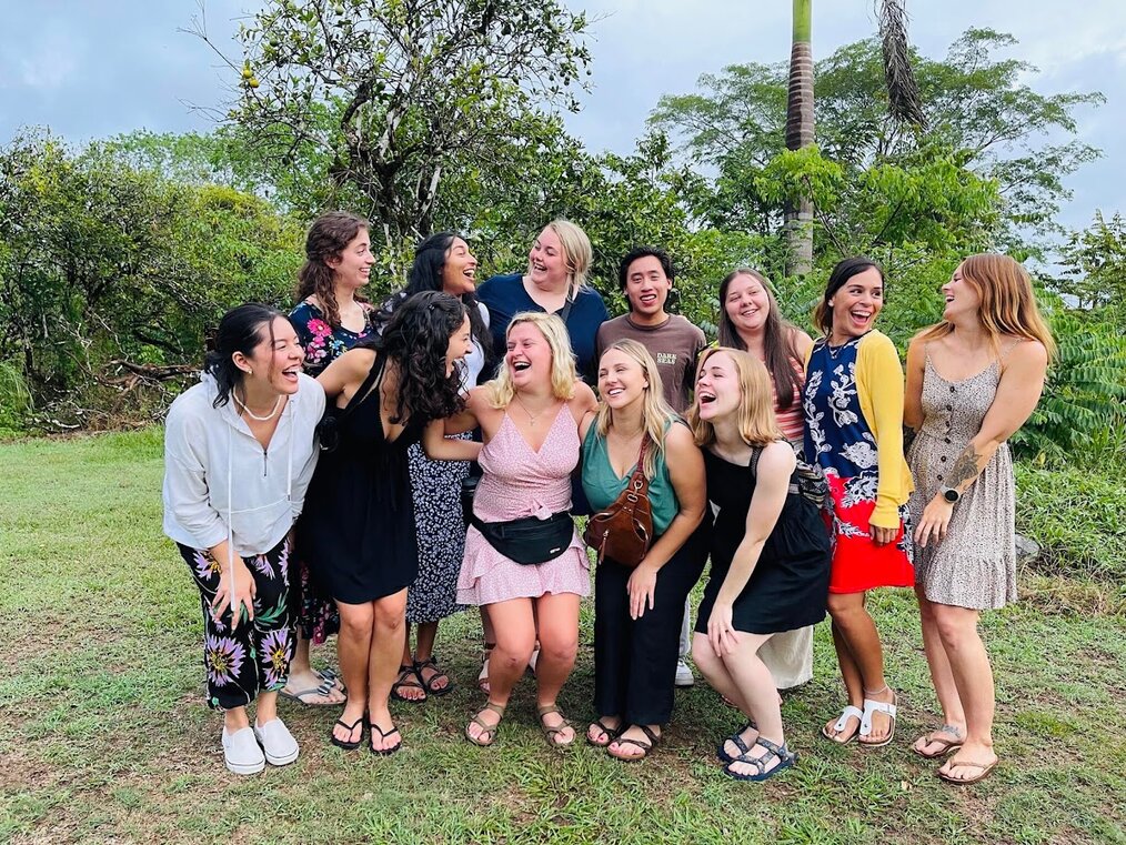 A group of women stand together and laugh.